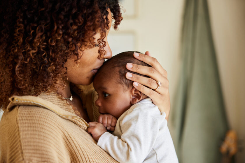 A woman is holding her baby in her arms.